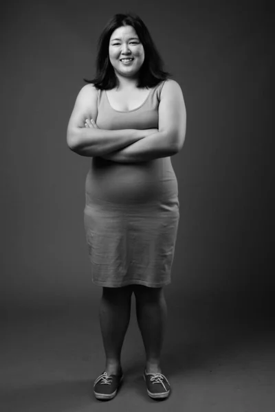 Schöne übergewichtige Asiatin vor grauem Hintergrund — Stockfoto