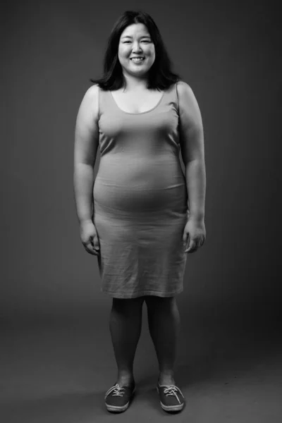 Gyönyörű túlsúlyos ázsiai nő szürke háttér — Stock Fotó