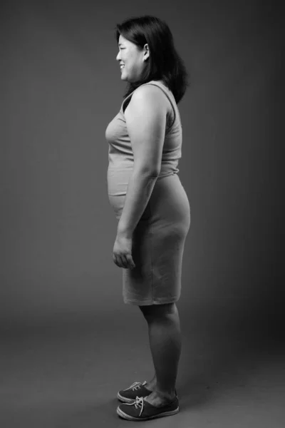 Vacker överviktig asiatisk kvinna mot grå bakgrund — Stockfoto