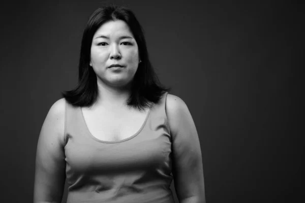 Hermosa mujer asiática con sobrepeso contra fondo gris — Foto de Stock