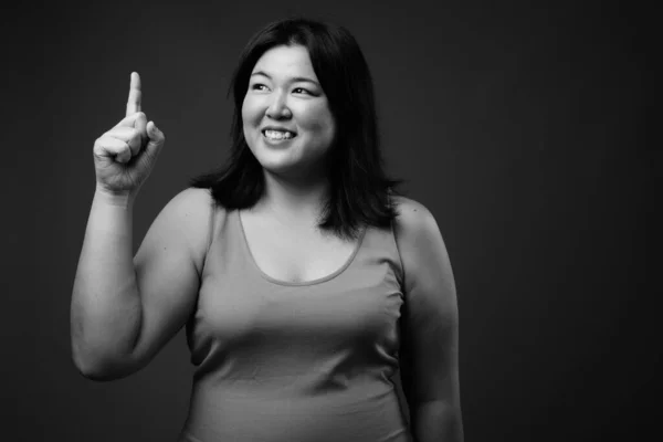 Bella donna asiatica in sovrappeso contro sfondo grigio — Foto Stock
