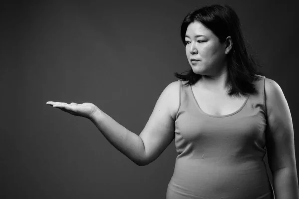 Hermosa mujer asiática con sobrepeso contra fondo gris — Foto de Stock