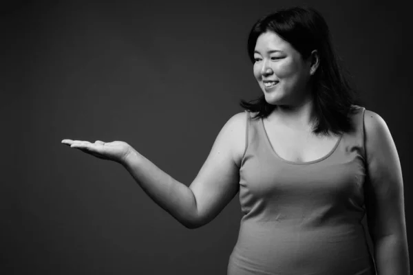 Bella donna asiatica in sovrappeso contro sfondo grigio — Foto Stock