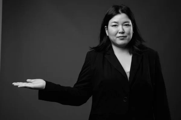 Hermosa mujer de negocios asiática con sobrepeso contra fondo gris — Foto de Stock