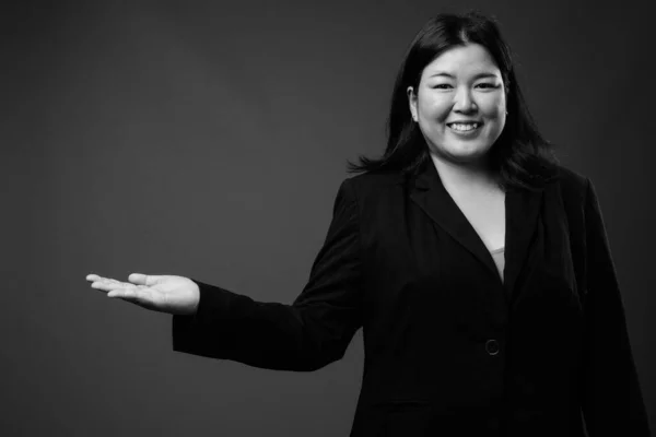 Красивая толстая азиатская деловая женщина на сером фоне — стоковое фото
