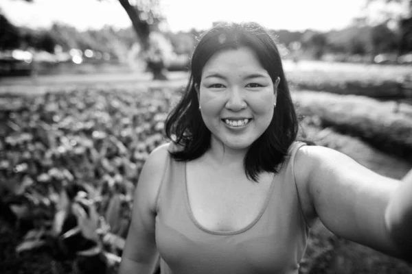 Krásná nadváha asijské žena relaxační v parku ve městě — Stock fotografie