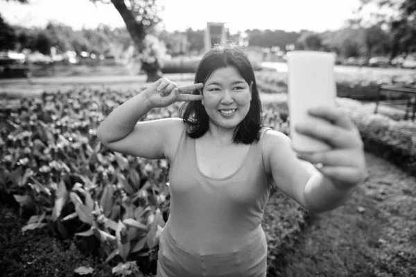 Belle femme asiatique en surpoids se détendre au parc dans la ville — Photo