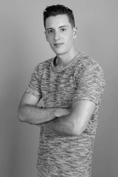 Junger gutaussehender Mann mit grauem Hemd vor grauem Hintergrund — Stockfoto