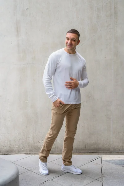 Full body shot of happy handsome man thinking and looking back — Stock fotografie