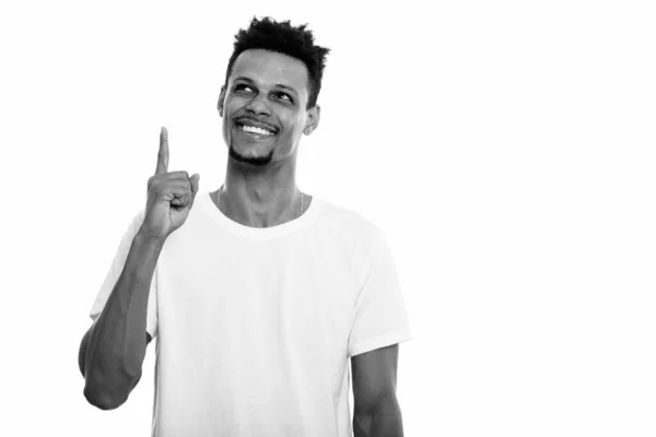 Pensativo jovem feliz Africano homem sorrindo enquanto apontando dedo para cima — Fotografia de Stock