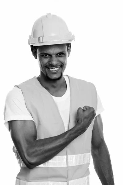Jong gelukkig Afrikaans man bouwvakker glimlachen met de hand op de borst — Stockfoto