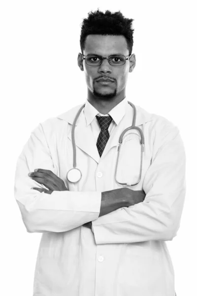 Studio shot of young African man doctor wearing eyeglasses with arms crossed — Stock Photo, Image