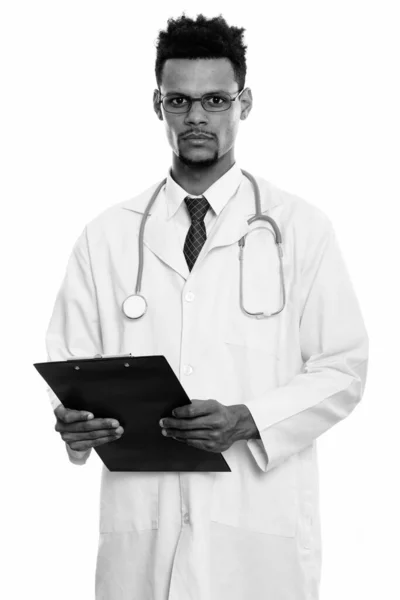Studio shot of young African man doctor holding clipboard — Stock Photo, Image