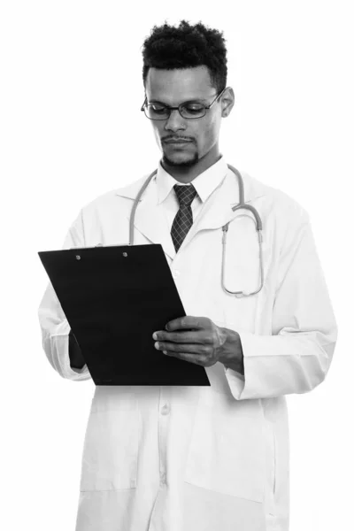 Estudio de joven africano doctor leyendo en portapapeles —  Fotos de Stock