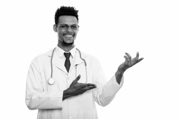 Young happy African man doctor smiling while showing something — Stock Photo, Image