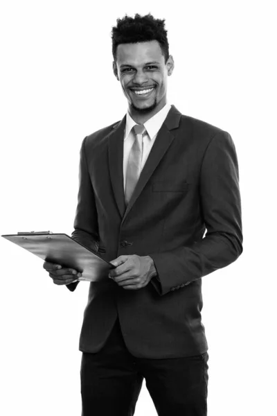 Joven empresario africano feliz sonriendo mientras sostiene el portapapeles — Foto de Stock