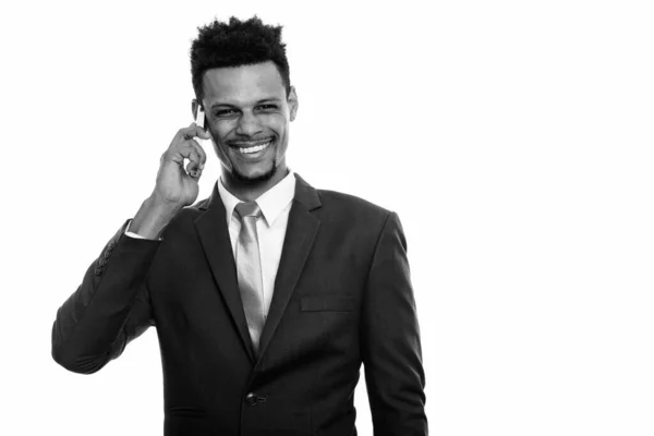 Genç mutlu Afrikalı işadamı cep telefonuyla konuşurken gülümsüyor — Stok fotoğraf
