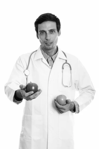 Studio shot de jeune homme beau médecin tenant deux pommes — Photo