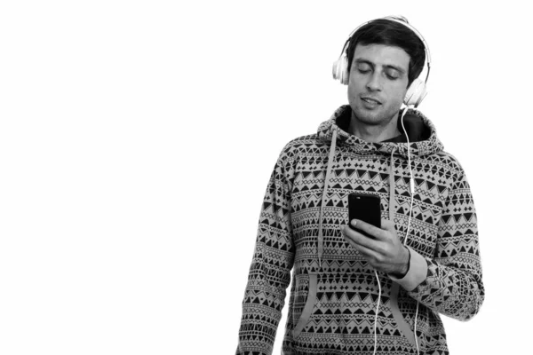 Studio shot de jeune homme beau écoutant de la musique tout en utilisant un téléphone mobile — Photo
