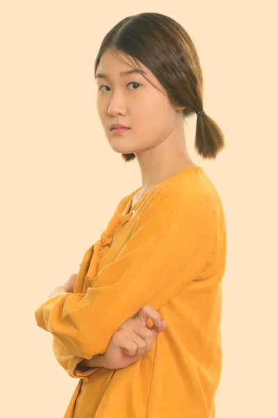 Studio shot van jong mooi aziatisch vrouw met armen gekruist — Stockfoto