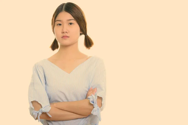 Studio colpo di giovane bella donna asiatica con le braccia incrociate — Foto Stock