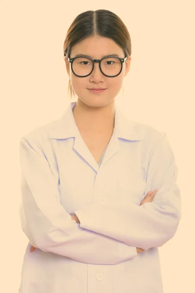 Studio skott av ung vacker asiatisk kvinna läkare med armarna korsade — Stockfoto