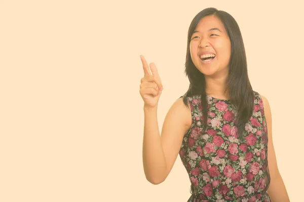 Junge glückliche Asiatin lacht, während sie mit dem Finger zeigt — Stockfoto