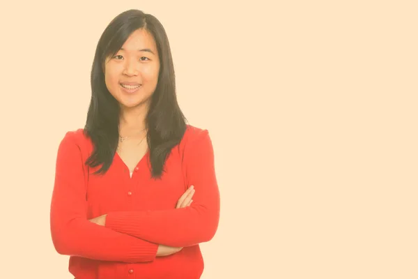 Retrato de feliz joven hermosa mujer asiática sonriendo con los brazos cruzados —  Fotos de Stock