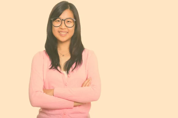 Retrato de feliz joven hermosa mujer nerd asiática sonriendo con los brazos cruzados —  Fotos de Stock