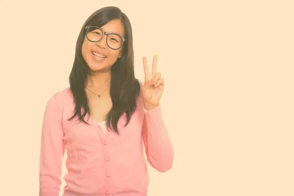 Young happy Asian woman giving peace sign — Stock Photo, Image