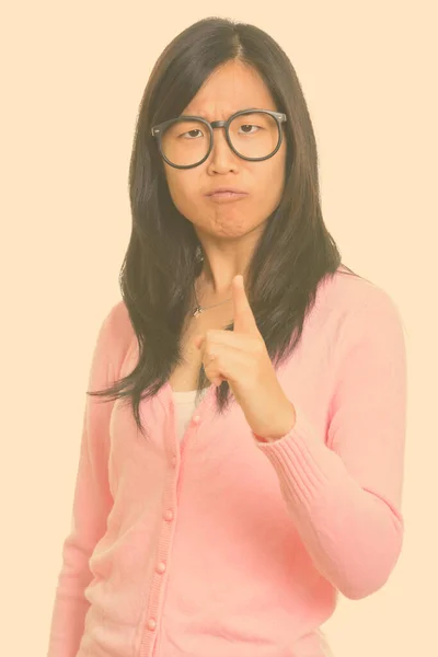 젊고 아름다운 아시아 여자가 손가락 질을 하면서 화난 표정을 짓고 있다 — 스톡 사진