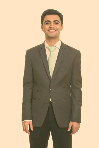 Portrait of happy young handsome Persian businessman in suit smiling — Stock Photo, Image