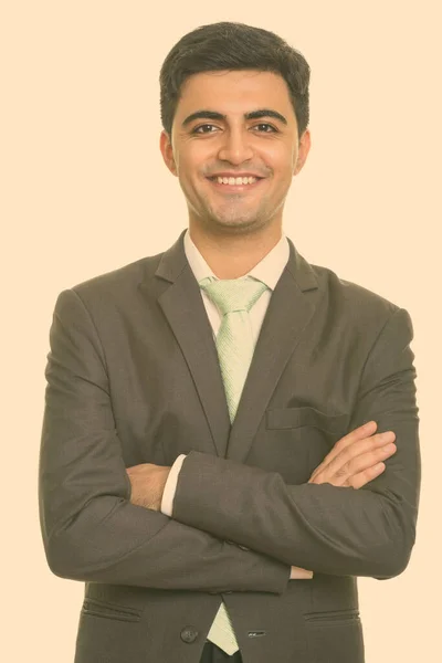 Retrato de feliz jovem bonito empresário persa em terno sorrindo com os braços cruzados — Fotografia de Stock