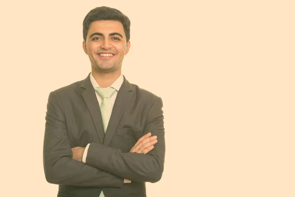 A boldog fiatal, jóképű perzsa üzletember portréja öltönyben, aki keresztbe tett kézzel mosolyog. — Stock Fotó
