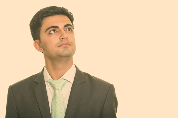 Porträtt av ung stilig persisk affärsman i kostym tänkande — Stockfoto