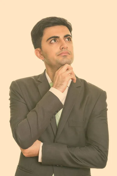 Retrato de joven hombre de negocios persa guapo en traje pensando —  Fotos de Stock