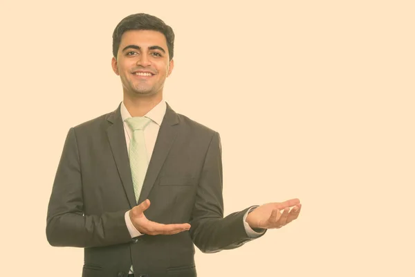 Porträt eines glücklichen jungen, gut aussehenden persischen Geschäftsmannes im Anzug, der etwas zeigt — Stockfoto