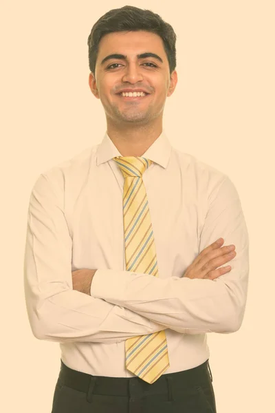 Retrato de feliz jovem bonito empresário persa sorrindo com os braços cruzados — Fotografia de Stock