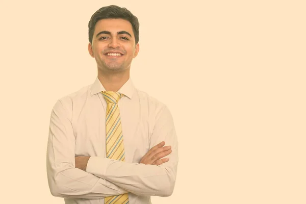 Retrato de feliz jovem bonito empresário persa sorrindo com os braços cruzados — Fotografia de Stock