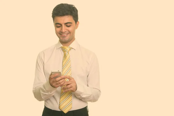 Молодой счастливый персидский бизнесмен с помощью мобильного телефона — стоковое фото