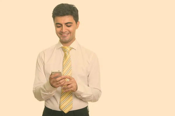 Young happy Persian businessman using mobile phone — Stock Photo, Image