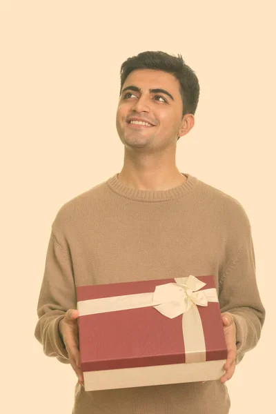Jovem homem persa feliz segurando caixa de presente enquanto pensa pronto para o dia dos namorados — Fotografia de Stock