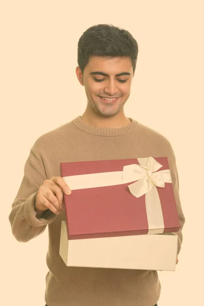 Jovem feliz homem persa caixa de presente de abertura pronta para o dia dos namorados — Fotografia de Stock