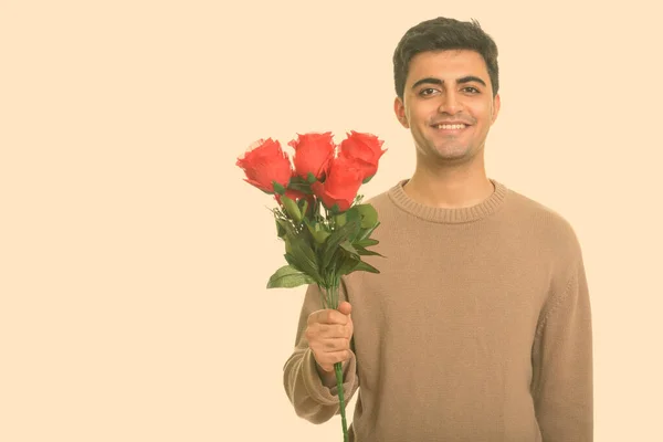 Jovem homem persa feliz segurando rosas vermelhas pronto para o dia dos namorados — Fotografia de Stock
