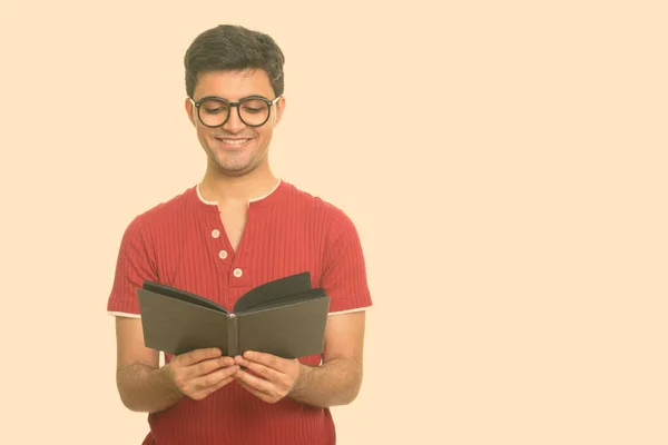 Портрет счастливого молодого красивого перса, читающего книгу в очках — стоковое фото
