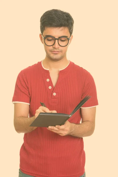 Young handsome Persian man writing on diary — Stock Photo, Image