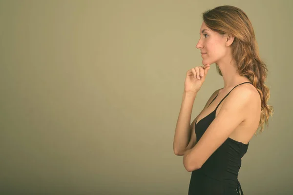 Young beautiful woman wearing sleeveless top against colored background — Stock Photo, Image