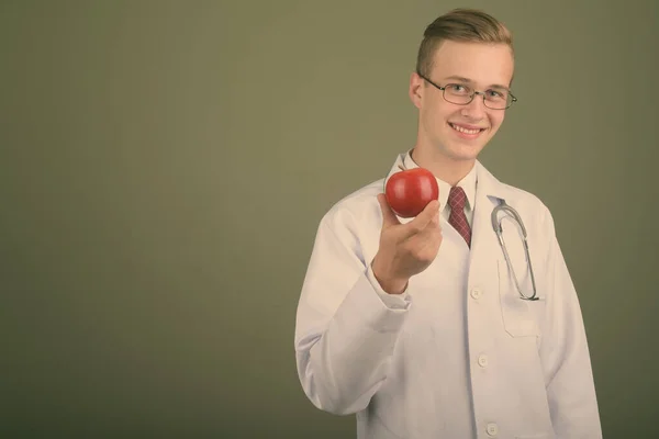 Jonge knappe man arts tegen gekleurde achtergrond — Stockfoto