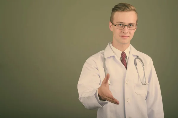 Jeune beau médecin homme sur fond de couleur — Photo