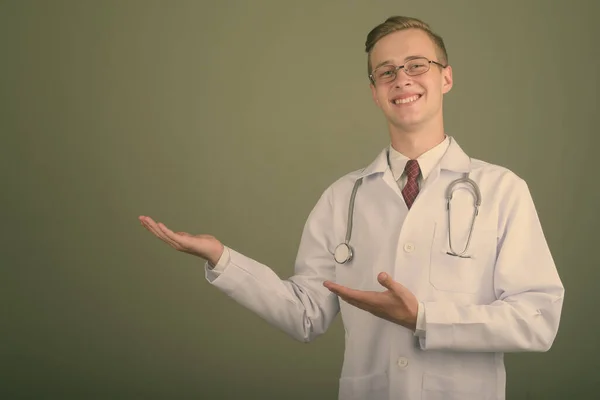 Ung stilig man läkare mot färgad bakgrund — Stockfoto